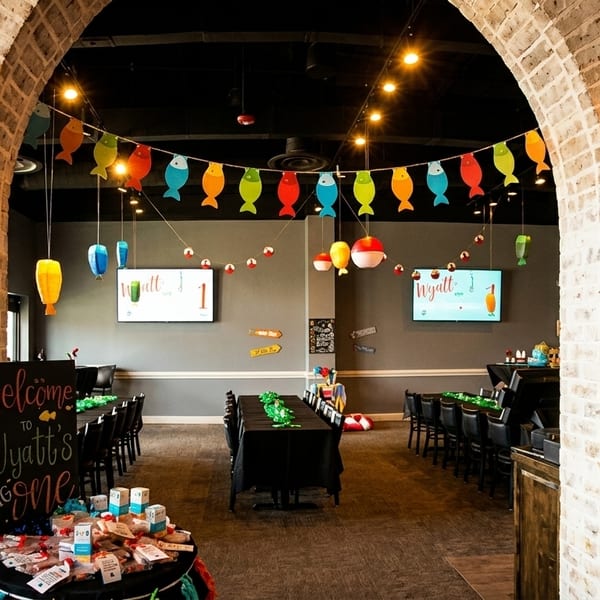 Restaurant interior decorated for a child's birthday party with fish banners and fishing bobbers.